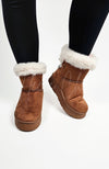 Winter boots with a back bow and fur trim are worn with a pair of black leggings - Fleece Chic