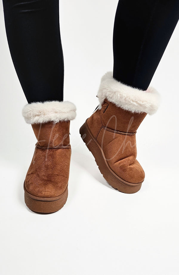 Winter boots with a back bow and fur trim are worn with a pair of black leggings - Fleece Chic