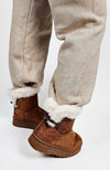 A person wears a pair of winter boots with a fur trim paired with knit pants by Fleece Chic.