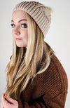 A woman with blonde hair wears Fleece Chic's beige Fleece Beanie paired with a brown sweater.