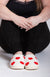 Women's slippers that are white with little red hearts by Fleece Chic.