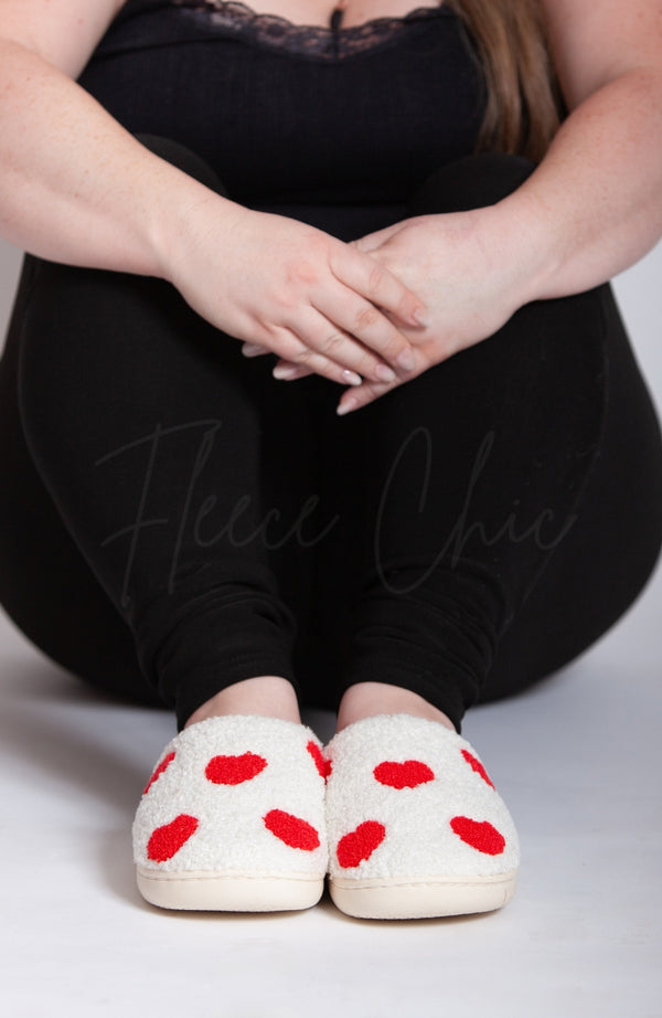 Women's slippers that are white with little red hearts by Fleece Chic.