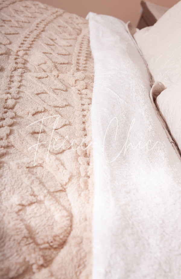 A detail shot of a sherpa comforter by Fleece Chic showing the fluffy top and bottom.