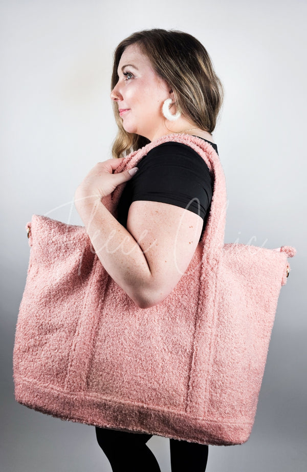 A woman with a zippered tote bag that is pink and made of shearling teddy material by Fleece Chic.