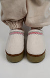 A person wears Curly Tasman Platform Slippers paired with a fleece suit by Fleece Chic.