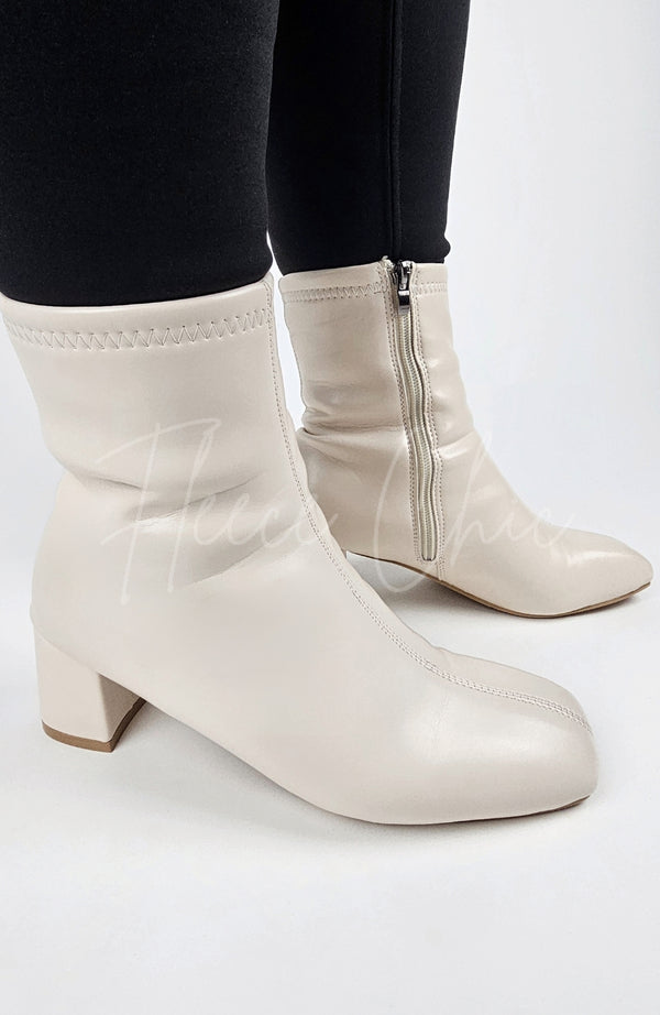 Leather Winter Boots that are cream-colored are worn by a woman in black leggings and have their sides displayed - Fleece Chic