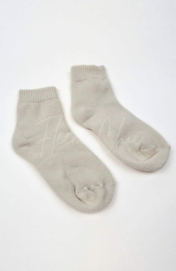 A pair of beige quarter socks on a white background by Fleece Chic.