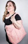 A woman smiles while a zipered tote bag by Fleece Chic is drapped over her shoulder.