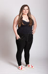A woman wears fuzzy white slippers with red hearts on them and black clothing - Fleece Chic