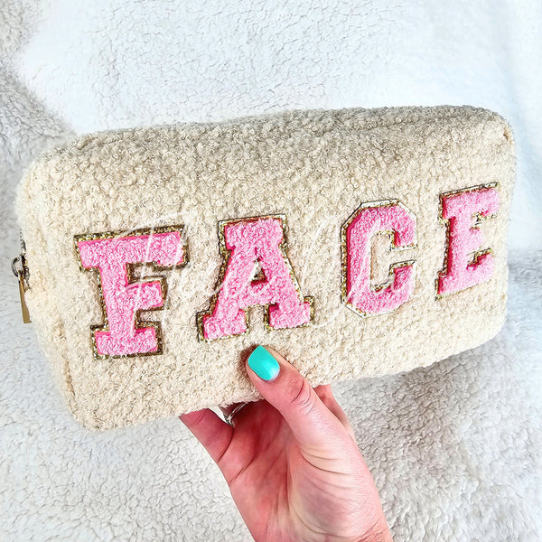 A soft bag for makeup or toiletries with chenille patches spelling the word "Face" is held up for display - Fleece Chic