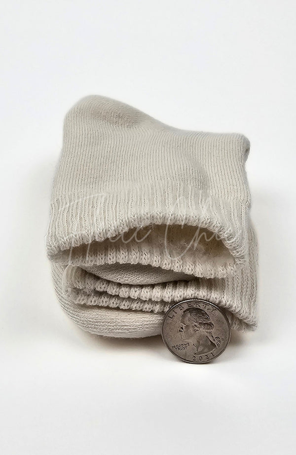 Thick folded beige quarter sock with a coin for scale on a white background - Fleece Chic