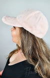 A side-profile view of a woman in a fluffy pink Fur Baseball Cap by Fleece Chic.