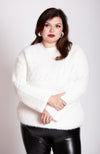 A woman wears a crew neck sweater that is white by Fleece Chic.