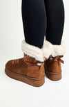 Winter boots with white fur trim and a back bow are worn with a pair of leggings - Fleece Chic