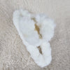 The top view detail of a white fluffy claw hair clip by Fleece Chic.