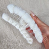 The underside detail of a white fluffy claw hair clip by Fleece Chic.