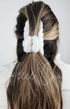 A claw hair clip that is fluffy and white is used in a half updo on a woman's brown long hair - Fleece Chic