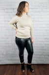 A woman poses in a cotton sweater and thermal leather leggings - Fleece Chic