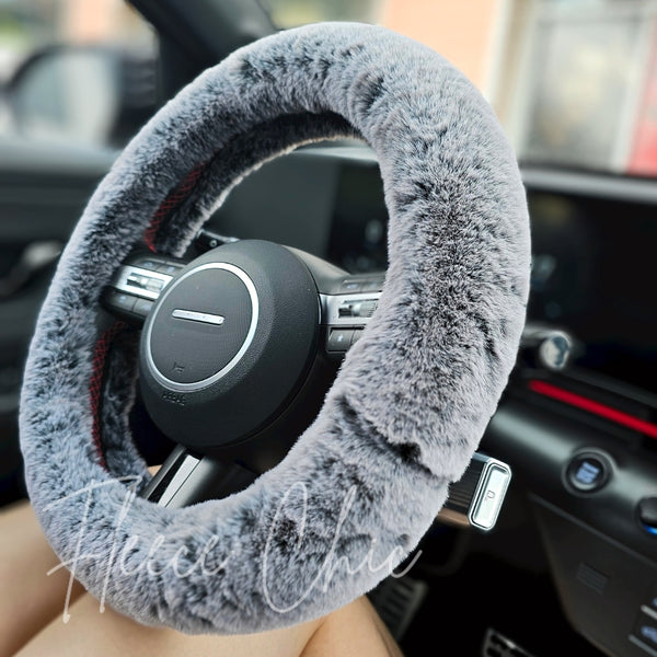 A close-up detail shot of a Fuzzy Steering Wheel Cover that is black that gradates into light gray - Fleece Chic