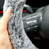 A close up detail shot of a Fuzzy Steering Wheel Cover that is black with white tips to look like real fur - Fleece Chic