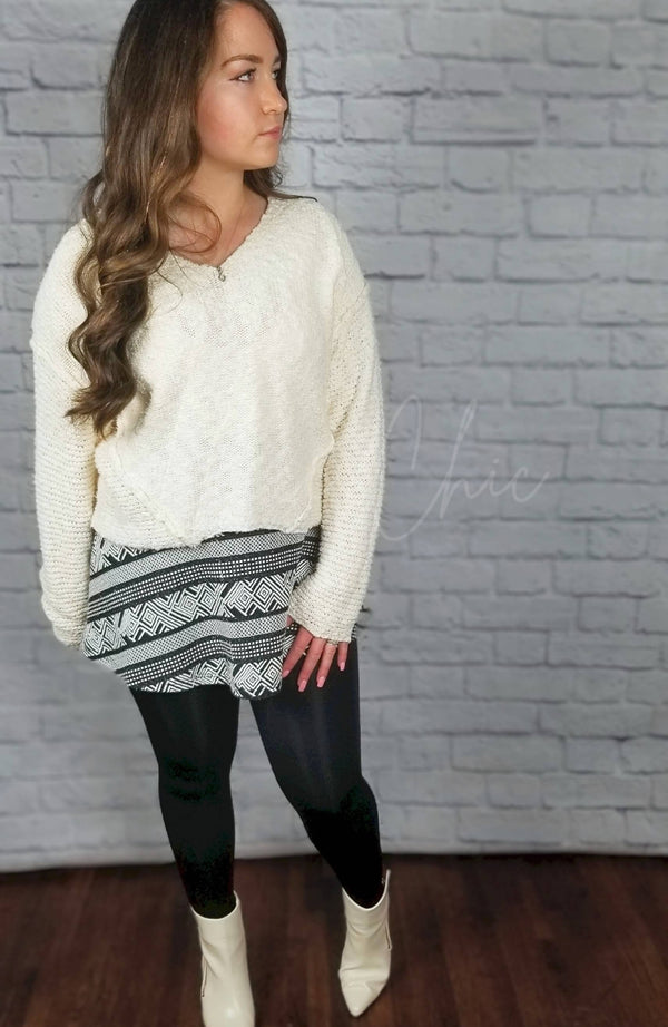 Fleece lined tights that are black with a plush lining are worn with a skirt, white sweater, and white boots - Fleece Chic
