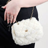 A fur purse that is white with a golden chain by Fleece Chic.