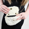 A woman poses with a fur purse open to show its inside - Fleece Chic