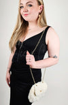 A woman in a black dress has a fur purse slung over one shoulder - Fleece Chic