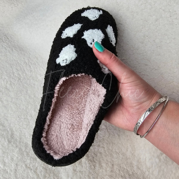 A fuzzy slipper with ghosts is held up for display - Fleece Chic