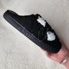 Fleece Chic’s black fuzzy slippers feature white ghost motifs in a cozy, stylish side profile perfect for spooky season.