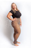 Plus size tights with a fleece lining in the stirrup style are worn with a black crop top - Fleece Chic
