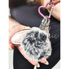 A close-up of a fur bag charm and keychain by Fleece Chic.
