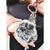 A close-up of a fur bag charm and keychain by Fleece Chic.