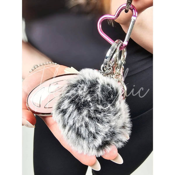 A close-up of a fur bag charm and keychain by Fleece Chic.