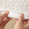 A detail shot of a sherpa chair cover that is white by Fleece Chic.
