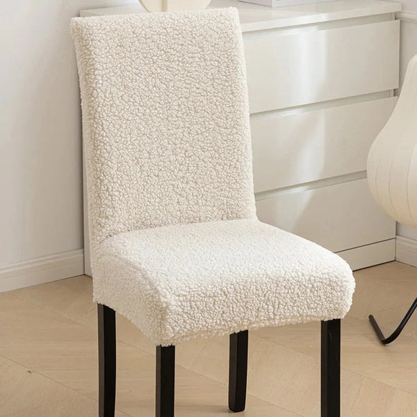 A white sherpa chair cover on a chair, providing a plush and cozy appearance while adding protection - Fleece Chic