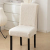 A white sherpa chair cover on a chair, providing a plush and cozy appearance while adding protection - Fleece Chic