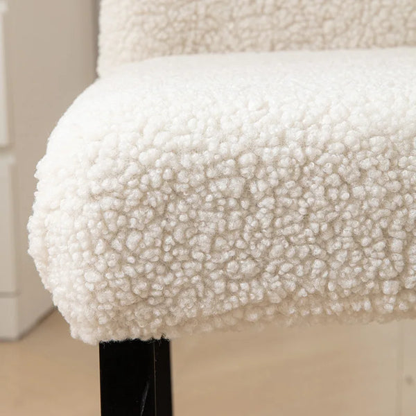 A detail shot of a white sherpa chair cover on a chair, providing a plush and cozy appearance while adding protection - Fleece Chic