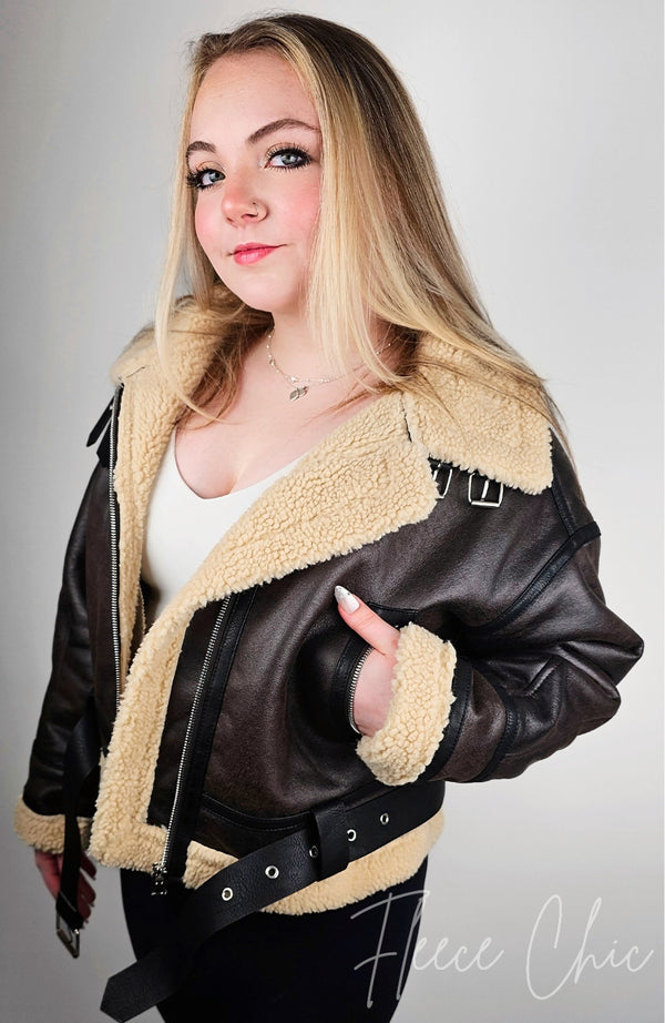 Woman wearing a Fleece Chic shearling jacket in aviator style with her hand in a pocket.