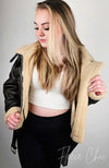 Blonde woman wearing a Fleece Chic shearling jacket in aviator style.
