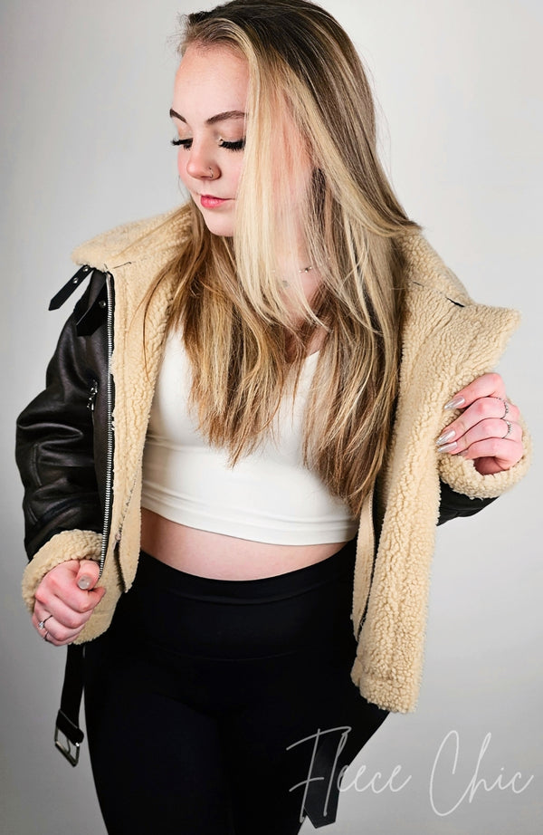 Blonde woman wearing a Fleece Chic shearling jacket in aviator style.