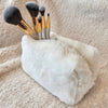 A small cosmetic fur bag has makeup brushes sticking out of it - Fleece Chic