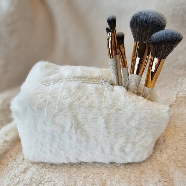 A small cosmetic fur bag with makeup brushes sticking out of it - Fleece Chic