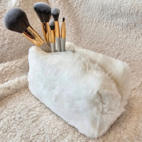 A small cosmetic fur bag has makeup brushes sticking out of it - Fleece Chic