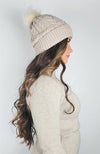 A woman wears a beige fleece beanie with a sherpa lining and cute pom pom - Fleece Chic