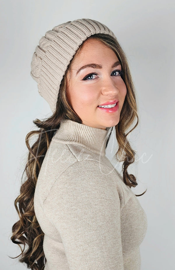A woman wears a sherpa lined fleece beanie with cute pom pom on it - Fleece Chic