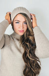 A woman wears a beige fleece beanie with a sherpa lining - Fleece Chic