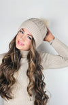 A woman wears a fleece beanie with a cute pom pom on it by Fleece Chic.