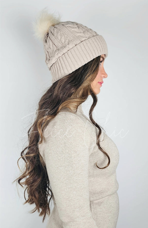 A woman wears a beige fleece beanie with a sherpa lining and cute pom pom - Fleece Chic