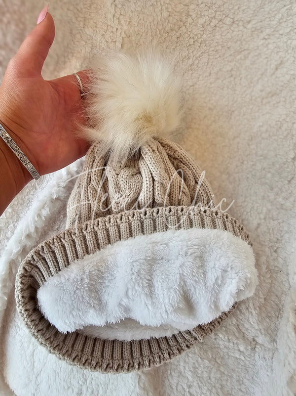 A beige fleece beanie by Fleece Chic has its cozy lining displayed.